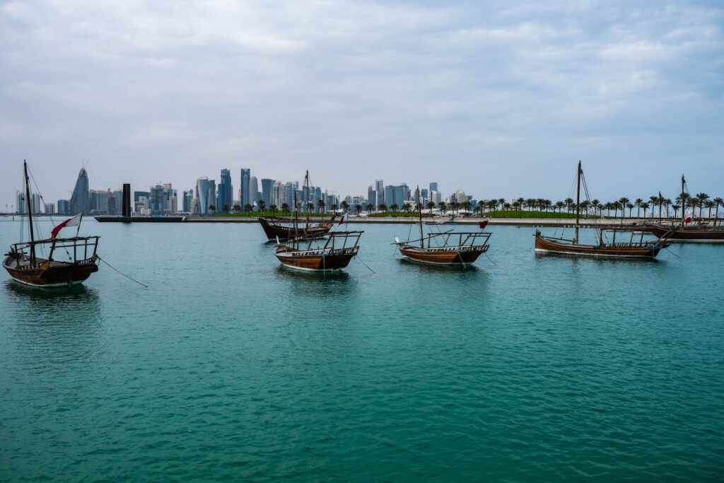 Tradycyjne katarskie łodzie cumują przy Corniche nadmorskiej promenadzie Doha Katar z dzieckiem stopover