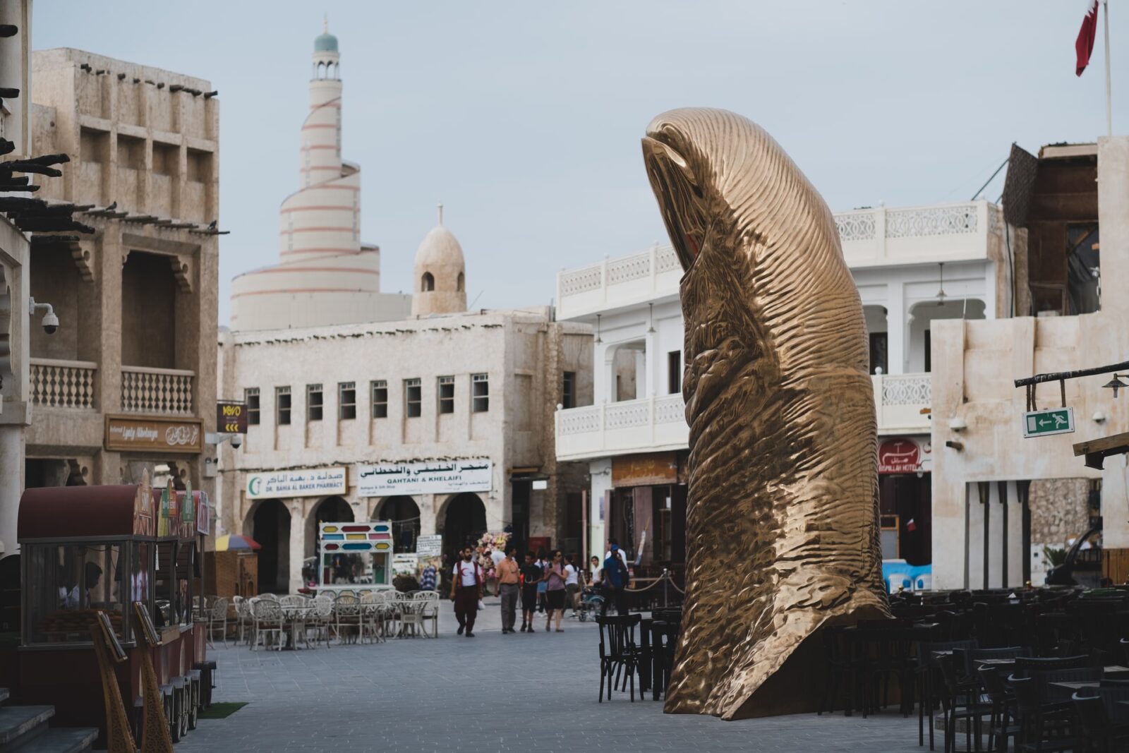 Rzeźba złotego palca i meczet w tle na Suku w Doha, Katar