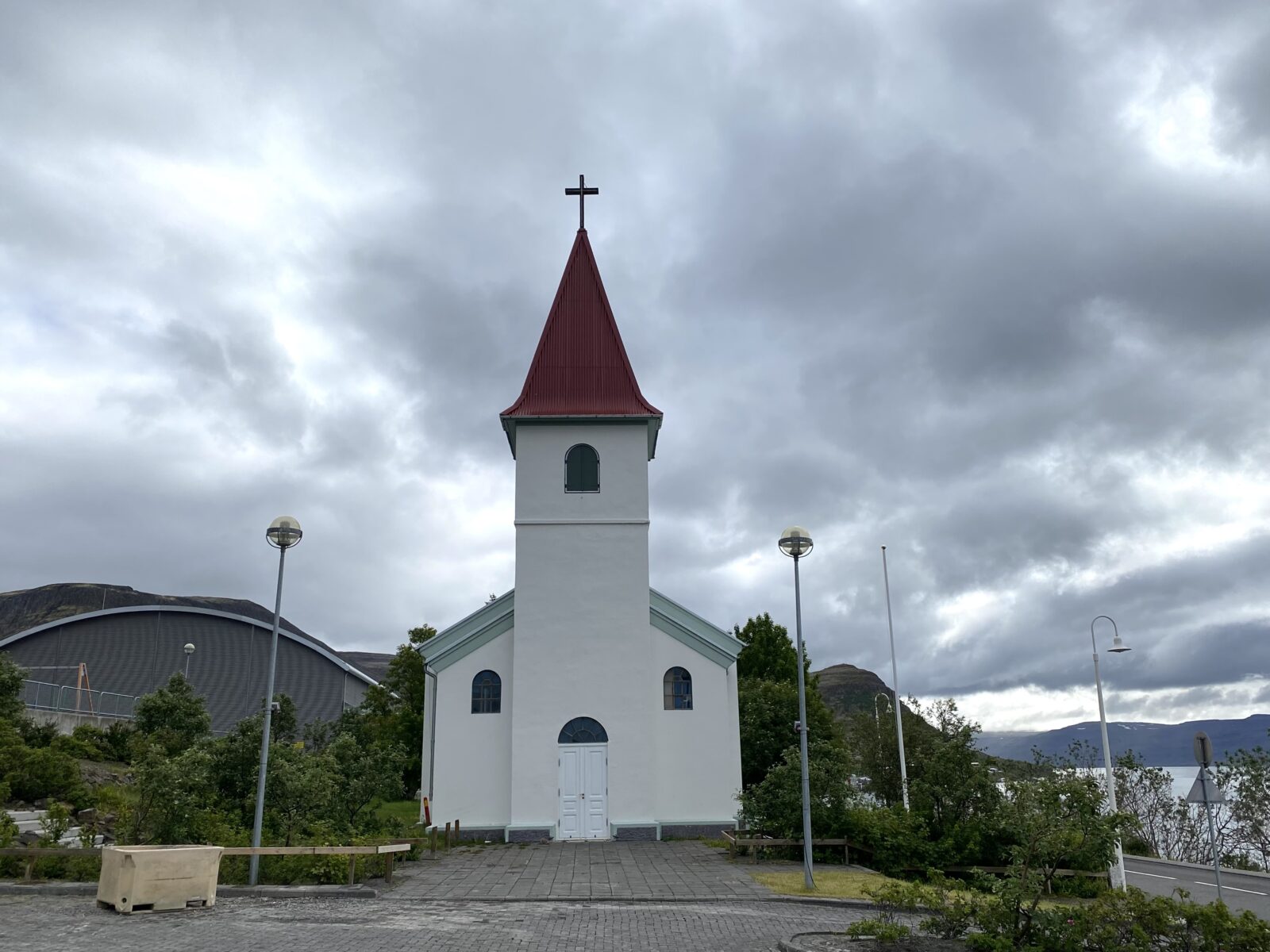 Patreksfjordur Westfjords biały kościółek z wieżą fiord w tle - Islandia poza głównymi szlakami